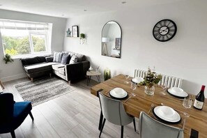 Un salon moderne comprenant un coin repas, un canapé, une table basse et une table à manger pour deux personnes.