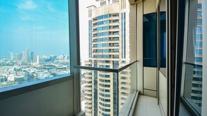 Um edifício alto com várias varandas, vista panorâmica da cidade e design arquitetônico moderno.