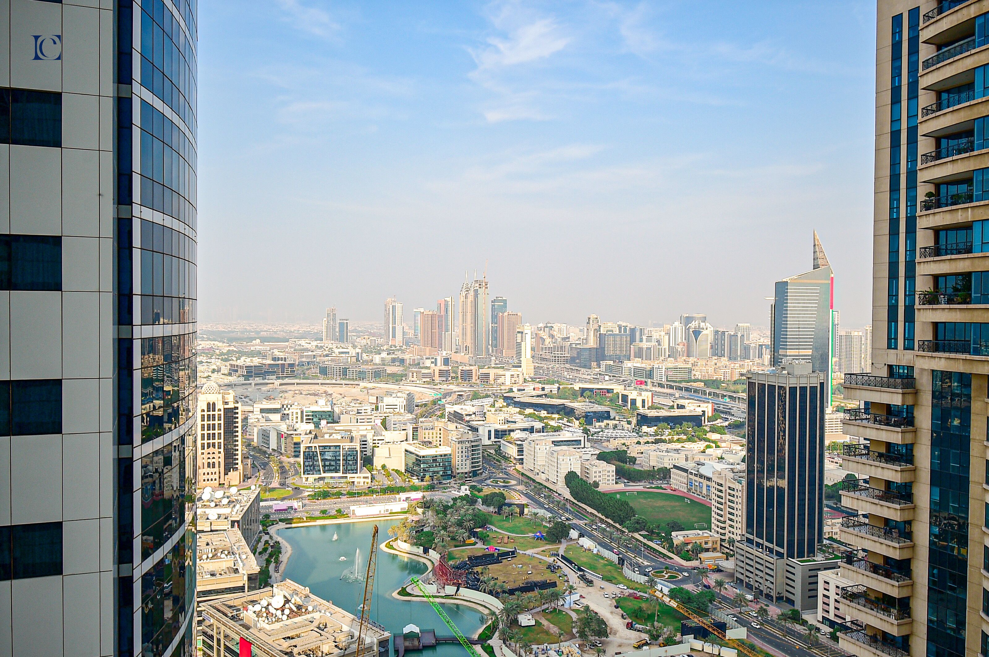 A high-rise building with a modern architectural design, featuring a prominent glass facade and multiple balconies.