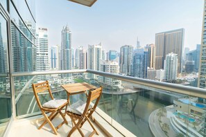 Een balkon met uitzicht op een stadsbeeld, inclusief hoge gebouwen en een waterpartij.