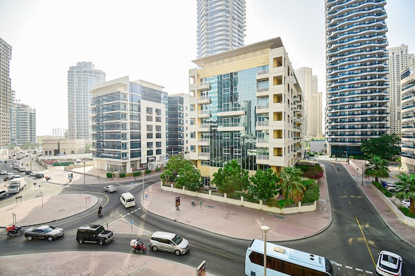 A modern urban intersection with high-rise buildings, a roundabout, and a pedestrian walkway.