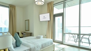 Une chambre d’hôtel moderne, dotée d’un grand lit, d’un bureau, d’une chaise et d’un téléviseur fixé au mur.