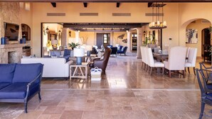 A spacious living area with a fireplace, seating arrangements, and a dining area. - 5-BR Luxury Golf Villa Retreat (Cabo San Lucas)
