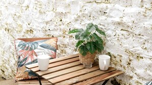 A wooden table with two white cups and a potted plant.