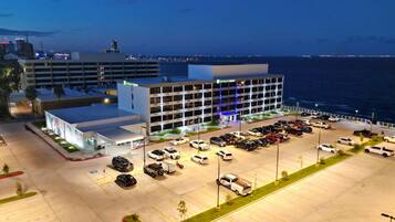 Ein Holiday Inn Express Hotel mit Parkplatz und Meerblick.
