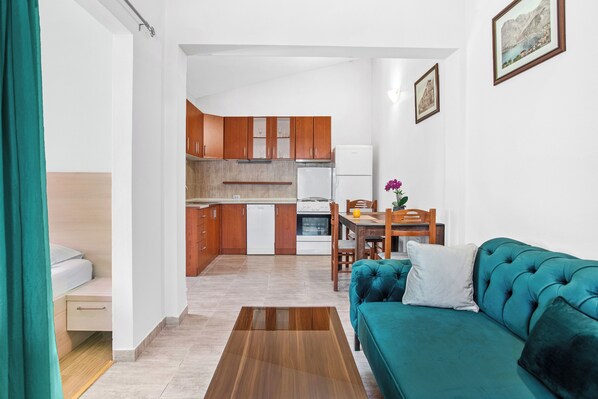 A compact living space with a kitchenette, a dining area, and a sofa. - Apartments Doncic (Kotor)