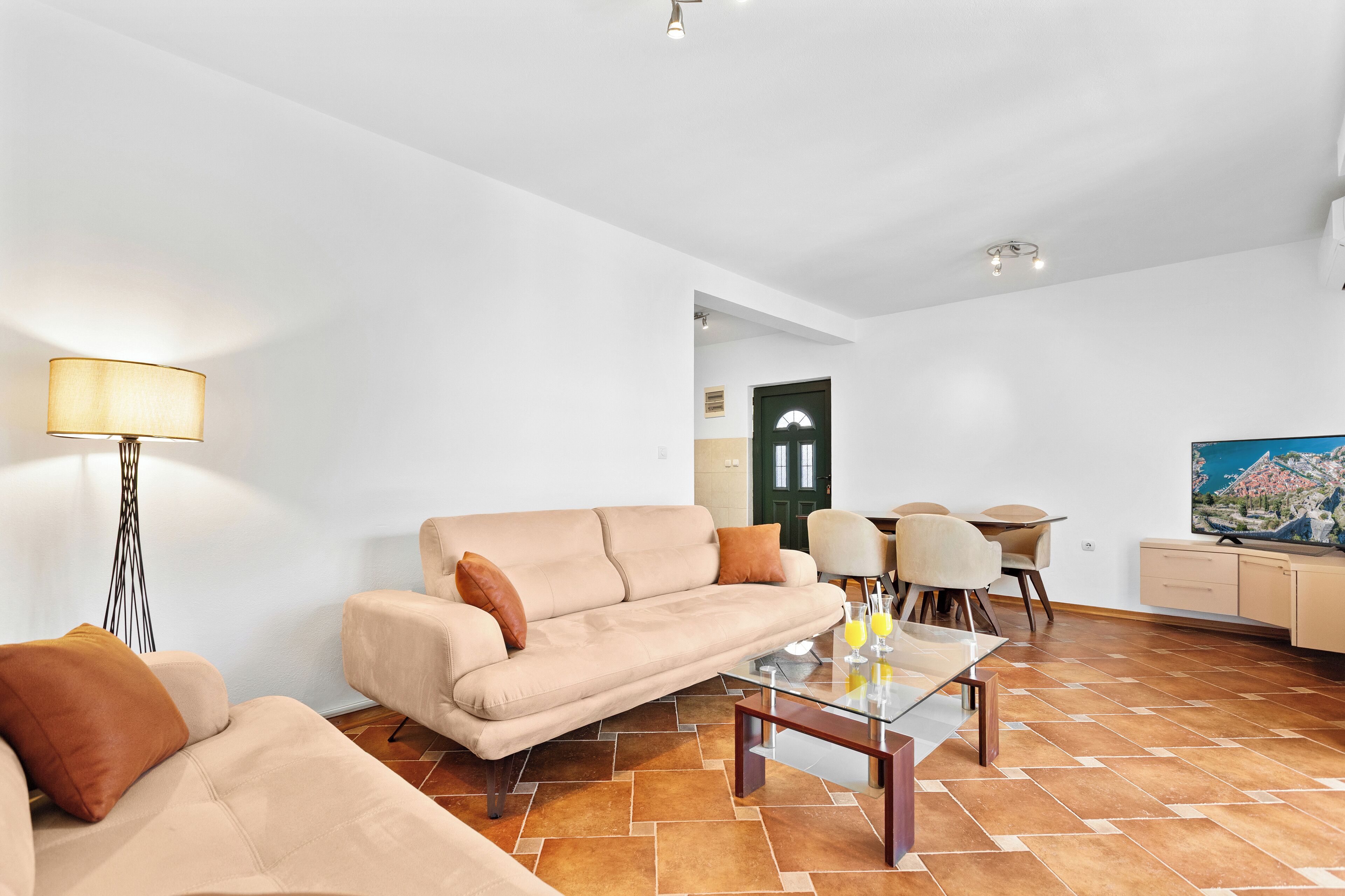 Una sala de estar moderna con sofá, mesa de centro y comedor.