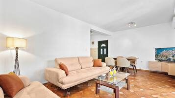 Una sala de estar moderna con sofá, mesa de centro y comedor.