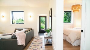 Une chambre moderne avec un lit, un canapé et une petite table sur laquelle est posée une plante.