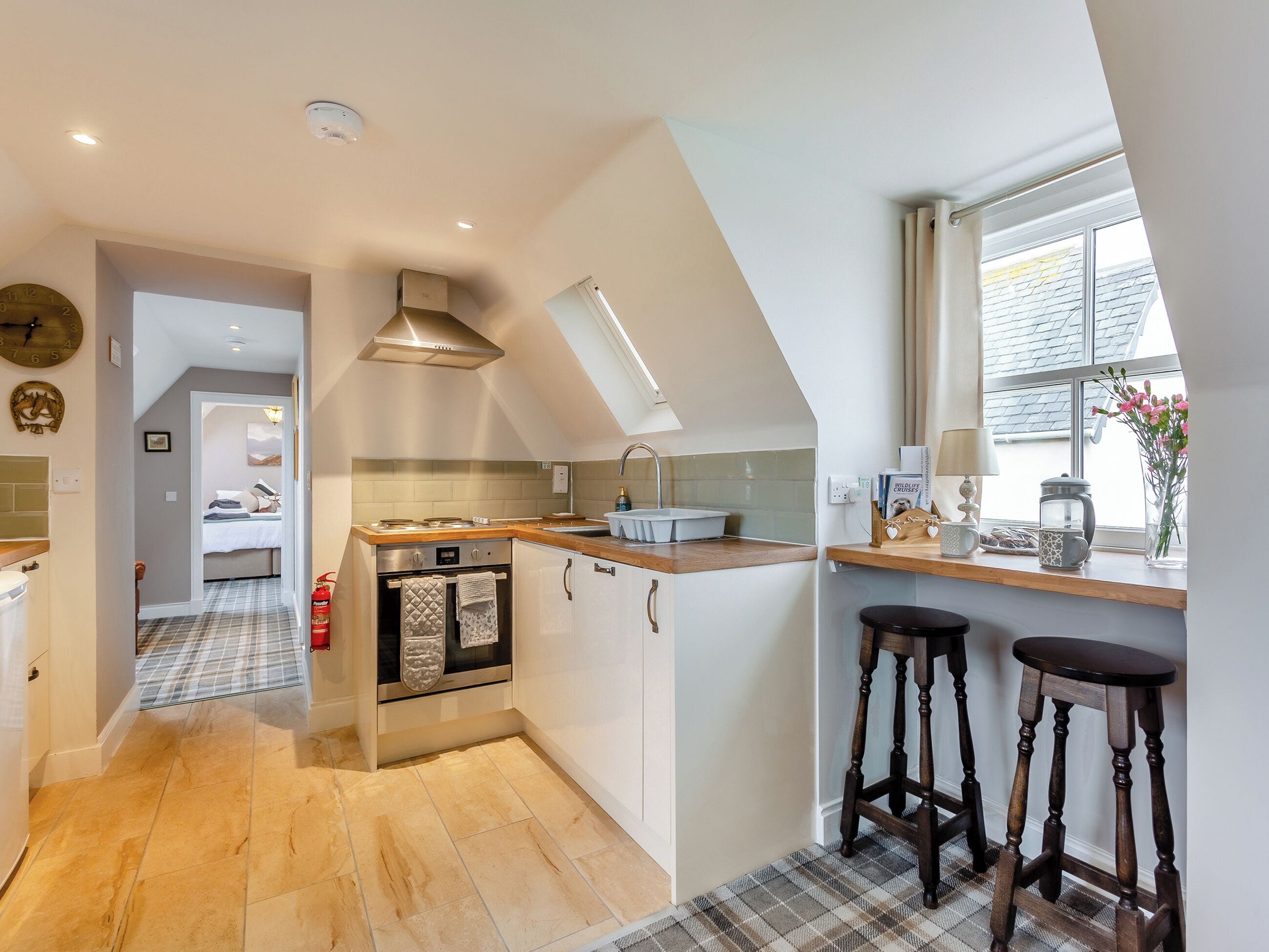 A modern kitchen with a central island, a built-in oven, and a window with a view.