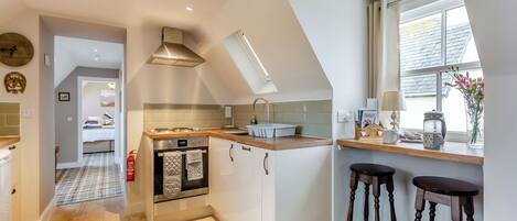 A modern kitchen with a central island, a built-in oven, and a window with a view.