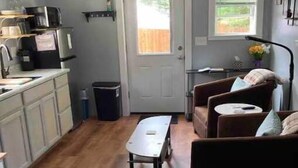 A compact living space with a kitchenette, a dining table, a sofa, and a window. - Simplicity-Just what you need! STR24-20 (Rockland)