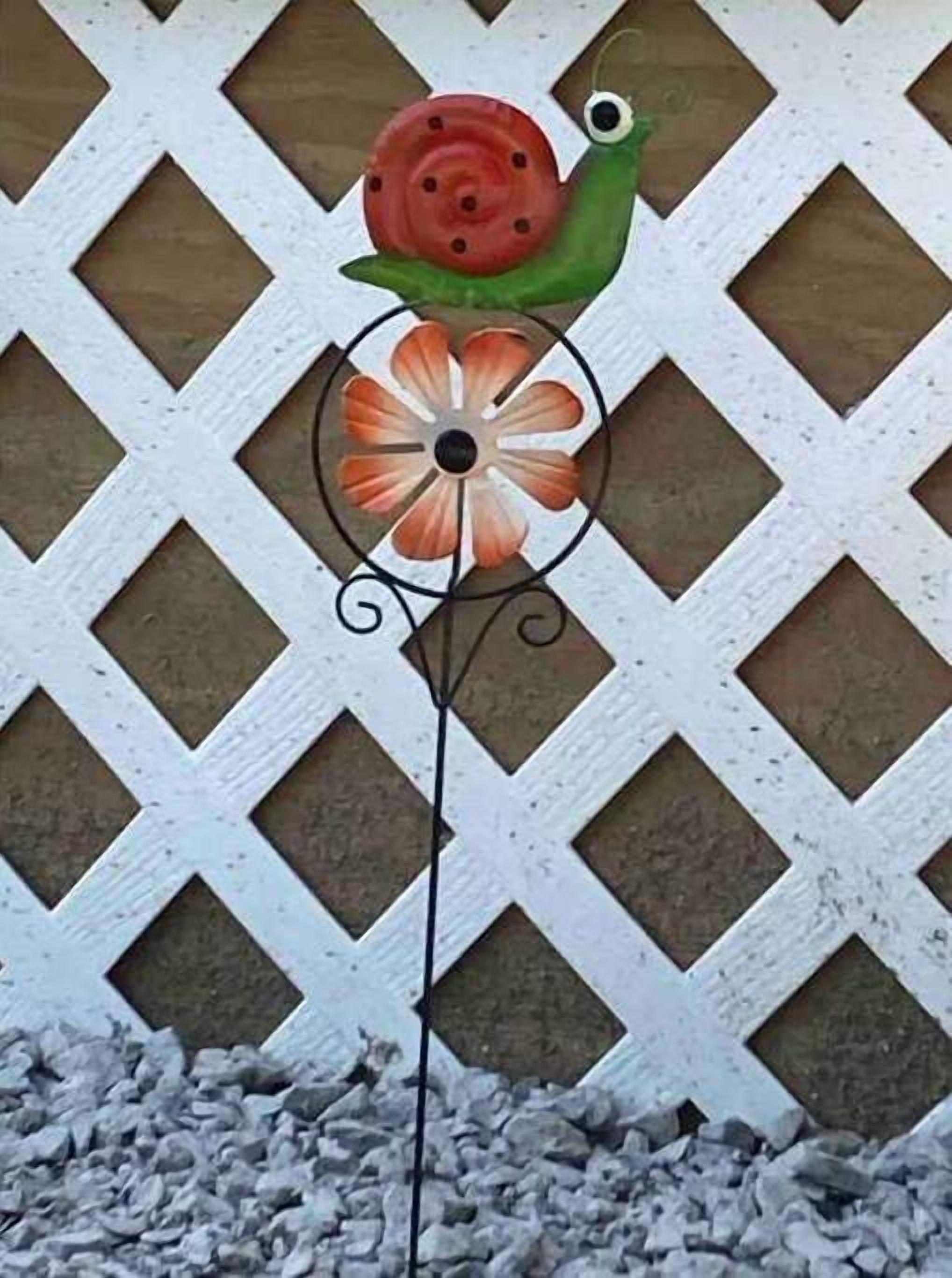 Una peça decorativa de metall amb un disseny de caragol i flor sobre un fons de celosía.