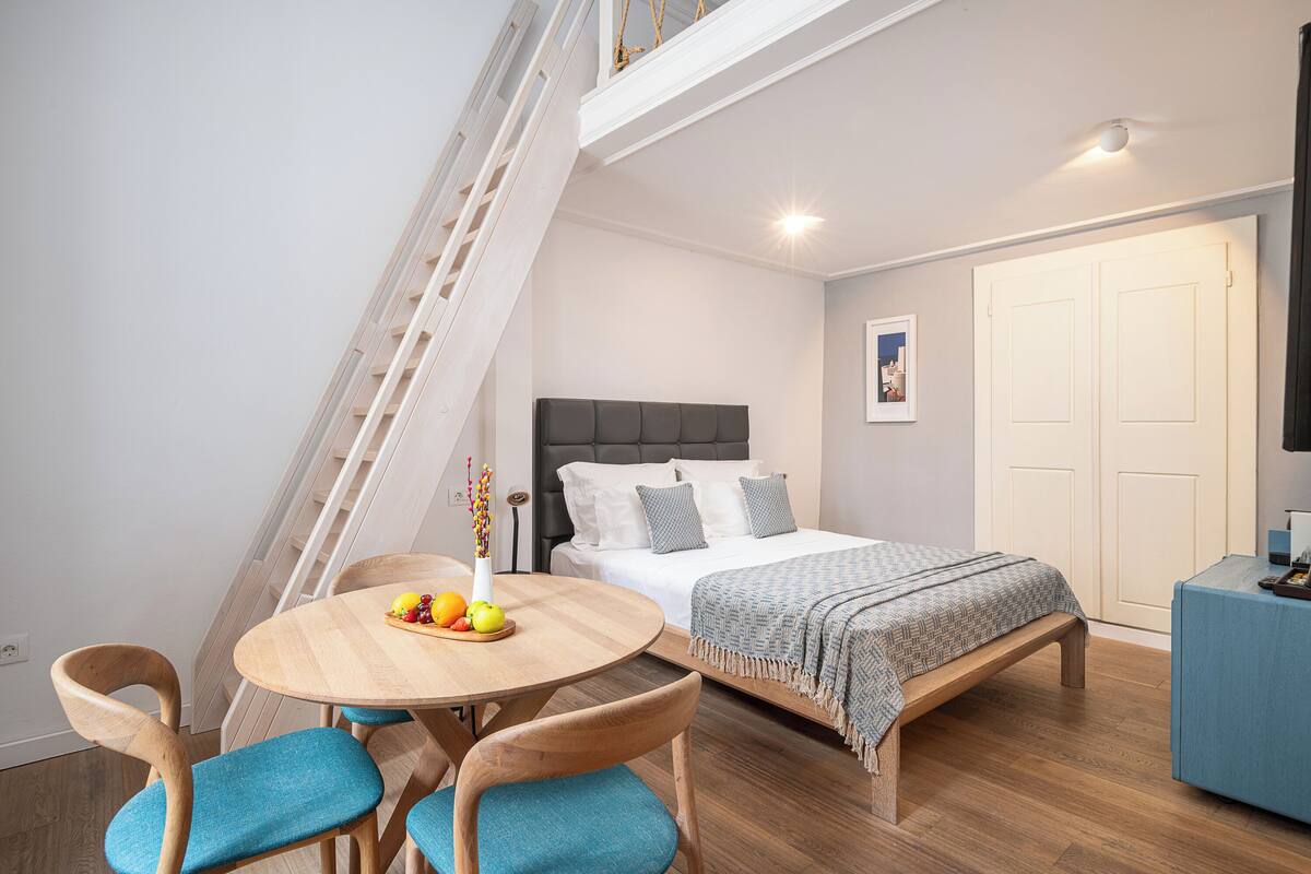 A bedroom with a bed, bedside table, and a desk.
