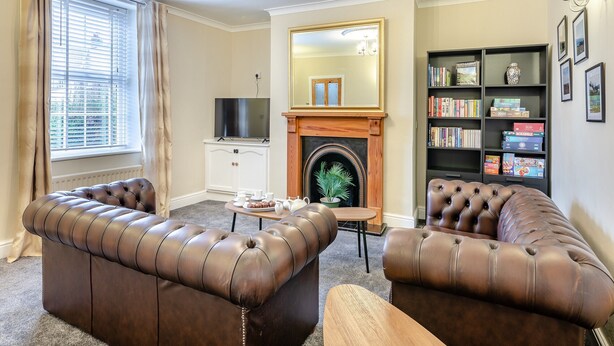 A living room with a fireplace, a television, and a bookshelf. - 3 bedroom accommodation in Alnwick (Alnwick)