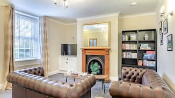 A living room with a fireplace, a television, and a bookshelf.