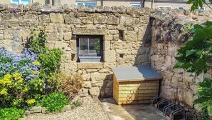 A stone-walled structure with a small window and a wooden box. - 3 bedroom accommodation in Alnwick (Alnwick)
