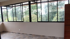 A room with a large window, a bed, and a tiled floor. - Bhakti Coffee Farm (Zipacon)