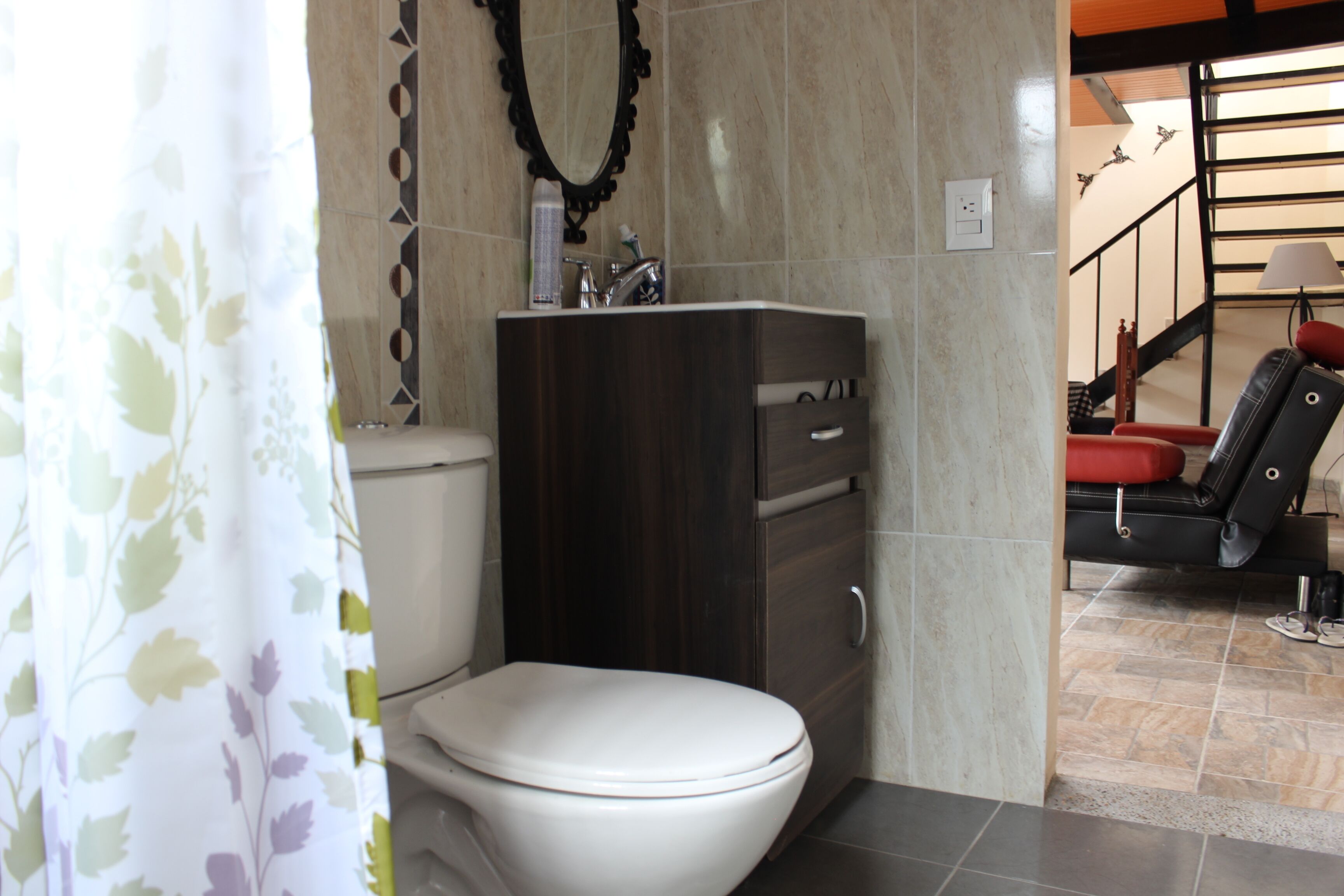 Un baño con inodoro, lavamanos y cortina de ducha.
