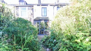 A garden pathway leading to a house with a conservatory. - Ribble Valley Cottage (Preston)