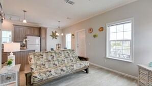 A spacious living area with a sofa, a dining table, and a kitchen in the background. - New Construction in Venture Out! 3 night minimum stay. (Cudjoe Key)