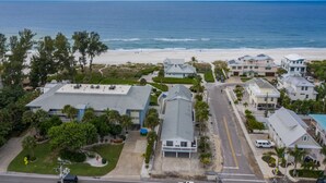 An aerial view of a coastal residential area with houses, a beach, and a clear sky. - 2 Bedroom End Unit, Hot Tub, Parking, - Steps from the Beach! (Holmes Beach)