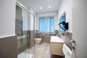 Bathroom features a glass-enclosed shower, toilet, and sink with a mirror.