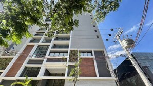 A modern multi-story building with a mix of glass and wood paneling, numbered 92 and 80. - Haus Residence Brooklin (São Paulo)