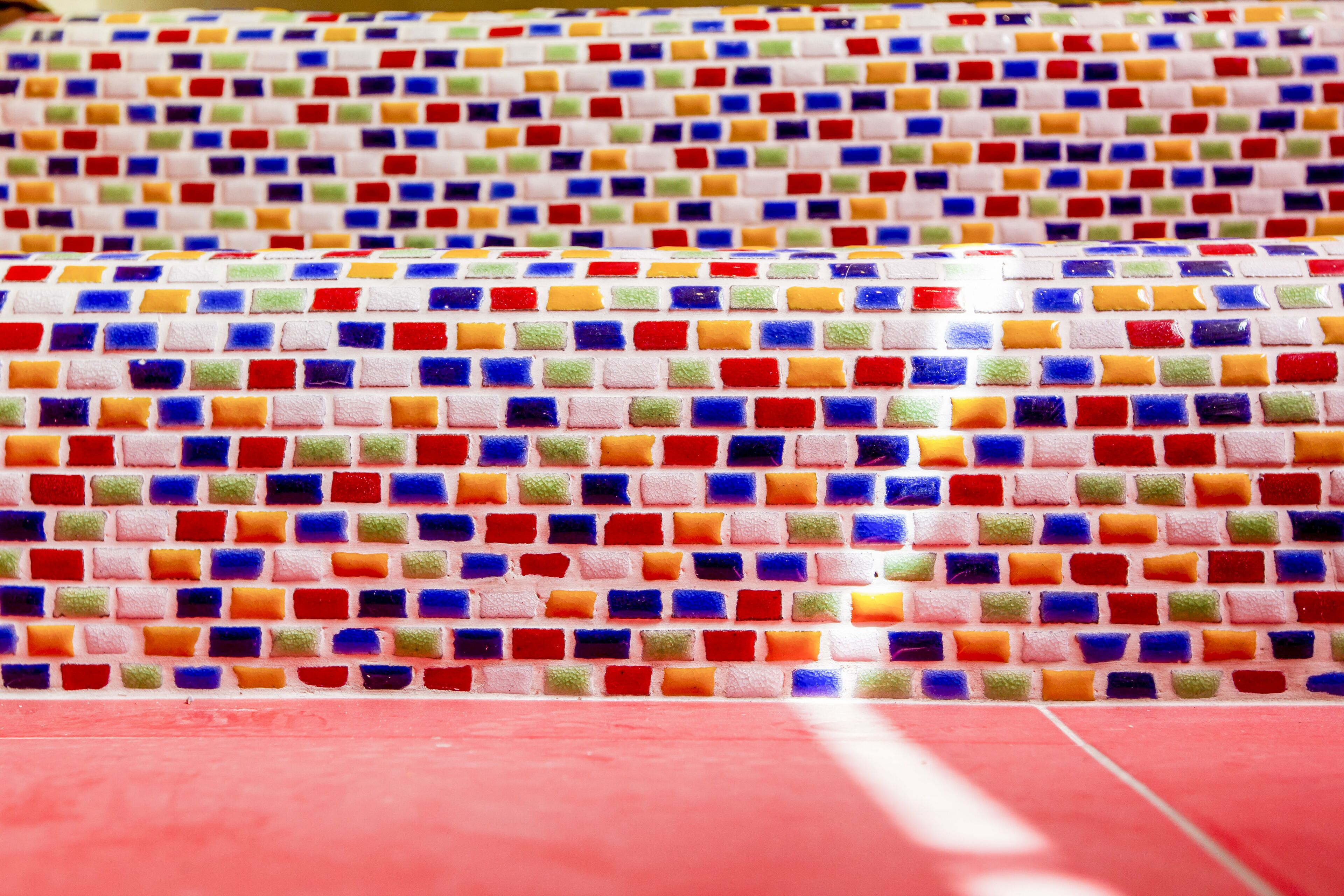 A tiled floor with a repeating pattern of multicolored square tiles.