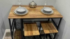 Un tavolo da pranzo con due sedie, un oggetto decorativo e un bicchiere di vino.