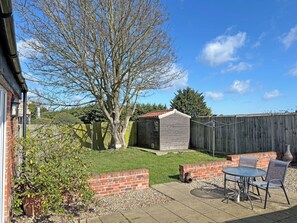 A backyard with a patio, a shed, and a fenced area. - 1 bedroom accommodation in Martham (Martham)
