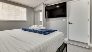 A bedroom with a bed, a TV mounted on the wall, a closet, and a window with blinds. - Cocoa Home w/ Large Yard: 3 Mi to Indian River! (Cocoa)