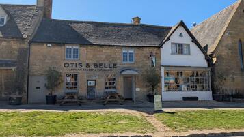 Un edificio de piedra tradicional con un cartel que dice 'OTIS & BELLE Artisan Bakery & Patisserie'.