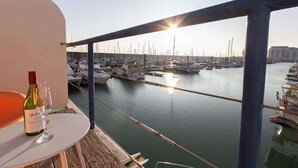 A balcony with a table and a bottle of wine, overlooking a marina with numerous boats. - Harbour Hideaway - Free Parking (Brighton and Hove)