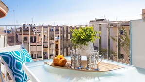 A balcony with a table, a potted plant, and a croissant. - Nice apartment for 6 people with WIFI, A/C, TV, terrace and pets allowed (L'ampolla)