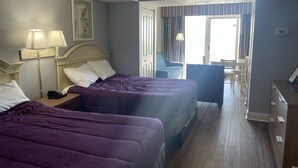A hotel room with two beds, a desk, a chair, and a view of the outside. - Oceanfront 2Qn Studio. Resort w/Lazy River, Pools (Myrtle Beach)