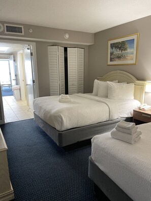 Une chambre d’hôtel avec un grand lit, une table de chevet avec une lampe, un tableau au mur et une armoire avec des portes coulissantes.