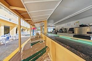 A deck area with outdoor seating, a pool, and a kitchen area with a coffee machine.