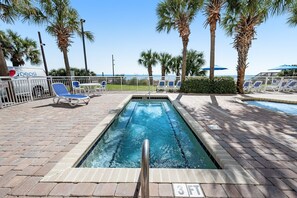 A swimming pool with a 3 FT depth marker, surrounded by palm trees and lounge chairs.