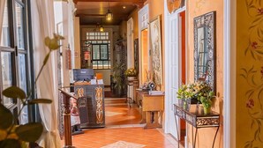 A hallway with wooden ceiling, a reception desk, and a sign that reads "Casa Colonial". - Casa Colonial Quito (Quito)