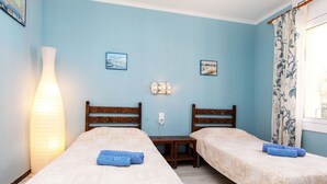 A room with two beds, a table, and a lamp. - Nice apartment for 4 people with WIFI, TV and terrace (Calonge)
