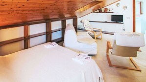 Une chambre à coucher avec un lit, une chaise et une petite table.