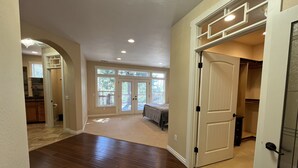 A spacious interior with hardwood flooring, a kitchen area, and a large sliding glass door leading to a deck.