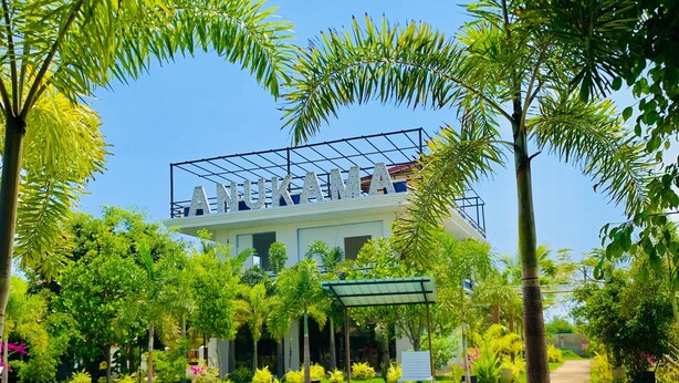 A hotel with a pool, surrounded by lush greenery and a clear blue sky. - Anukama Resort  (Nilaveli)