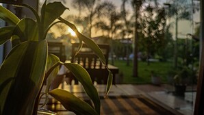A room with a large window, a wooden bench, and a potted plant. - Anukama Resort  (Nilaveli)