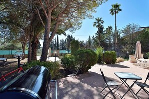 Eine Terrassenanlage mit Sitzgelegenheiten im Freien, einem Pool und verschiedenen Bäumen.