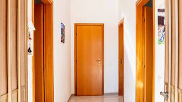 Un pasillo con puertas de madera y suelo de baldosas.