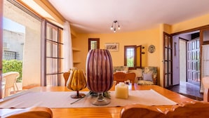 Un coin repas avec une table en bois, deux chaises, un vase et une bougie.