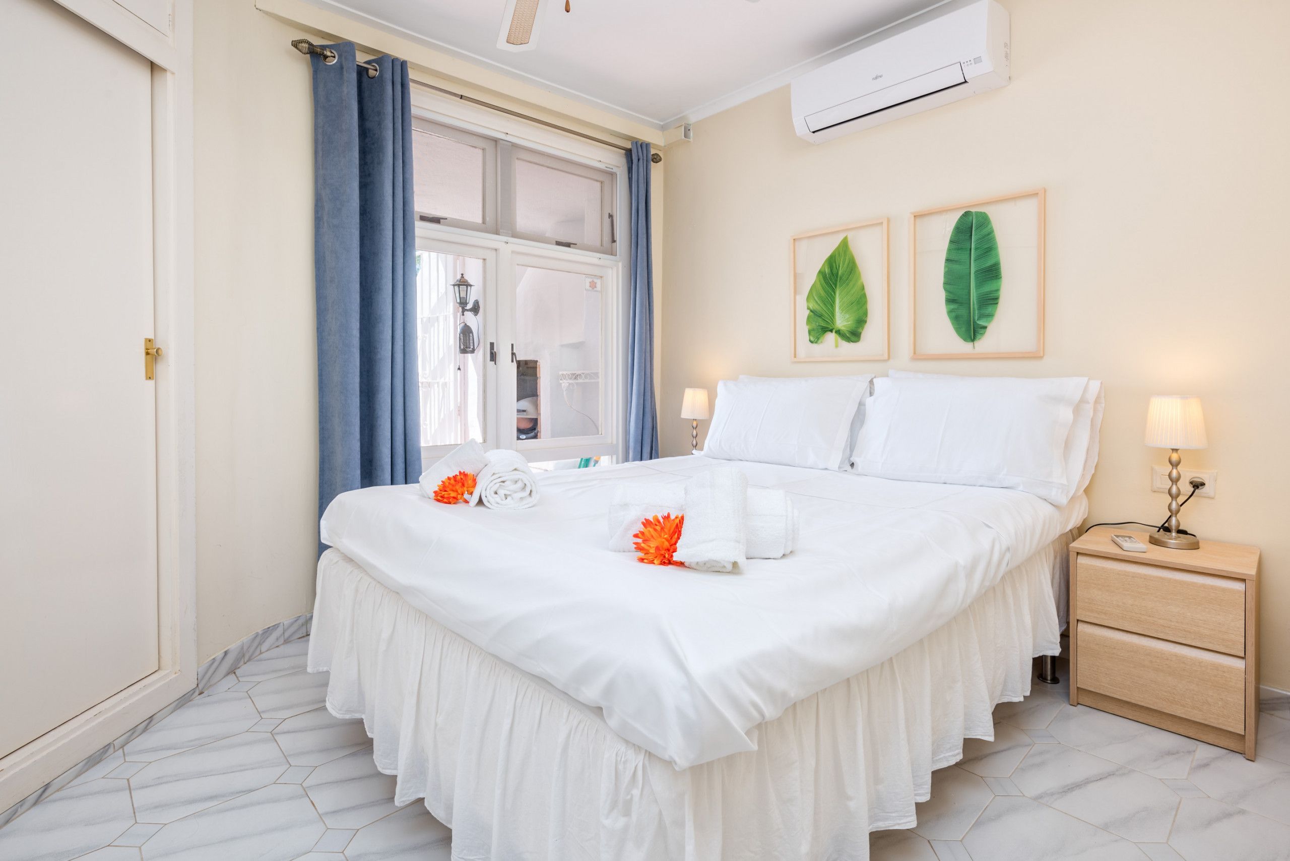 Une chambre à coucher bien rangée, avec un grand lit, une table de chevet et une commode.