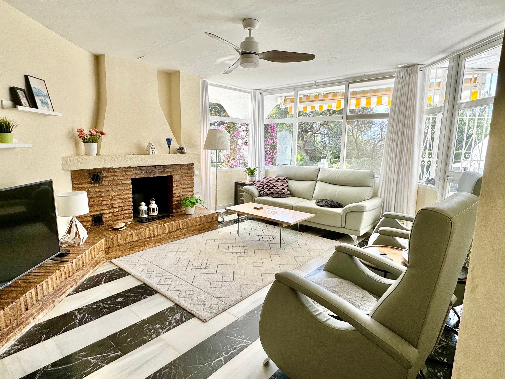 A living room with a fireplace, a sofa, a coffee table, and a TV.